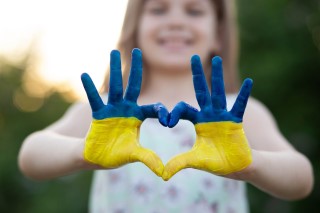 girls hands painted in the color of the ukrainian flag